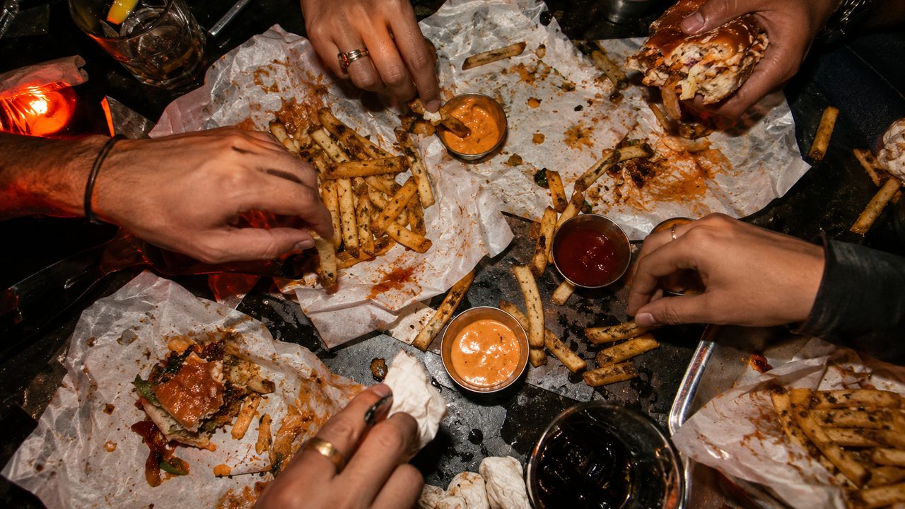 Friends sharing Hot Mess burgers and fries