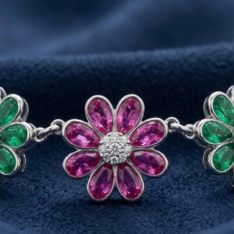 Macro photograph of the necklace’s green and pink floral settings on deep navy fabric.