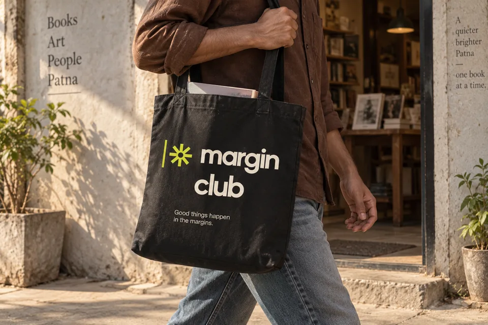 An Indian reader carries a black Margin Club canvas tote past an art bookshop.